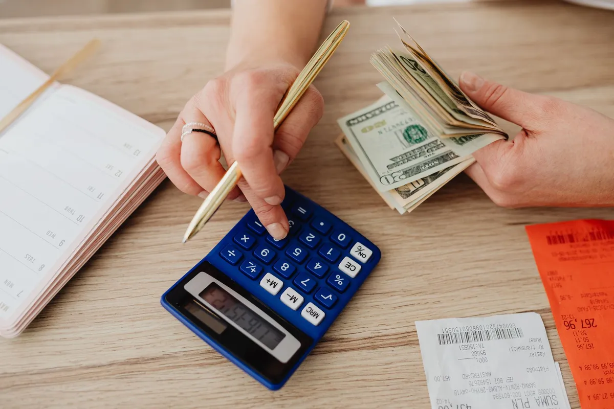 Calculadora e dinheiro representando quanto custa um cardápio digital próprio